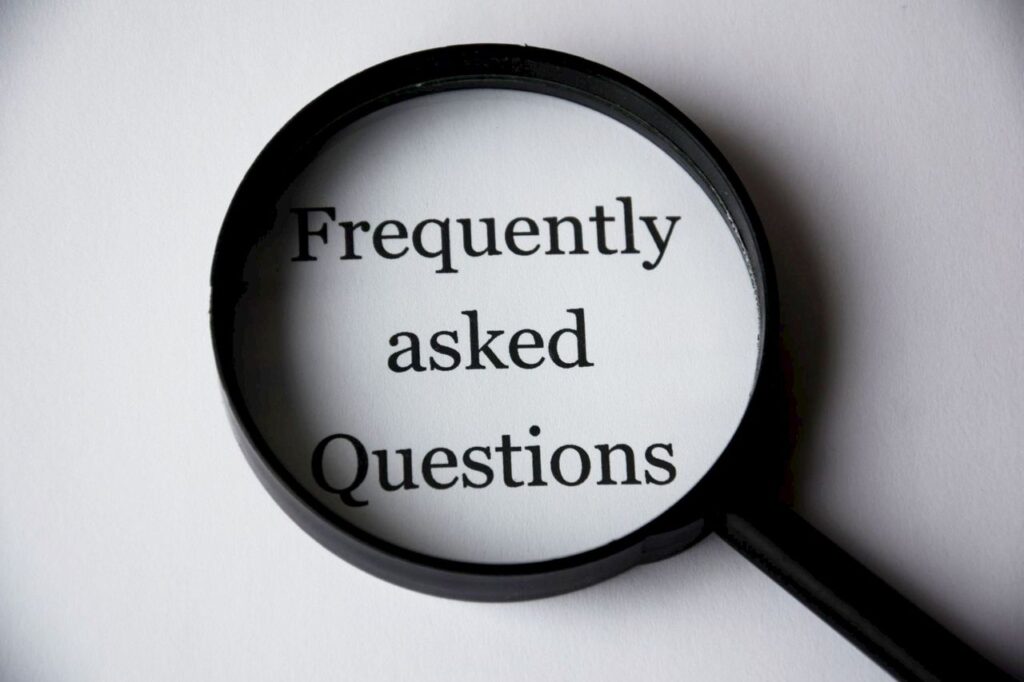 pexels-photo-221164-221164 Close-up of a magnifying glass focusing on the phrase 'Frequently Asked Questions'.