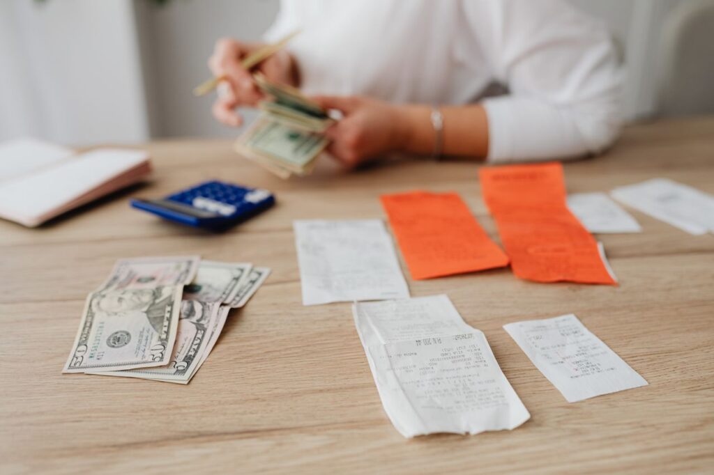 pexels-photo-5900178-5900178 A person using a calculator and cash to plan a household budget.